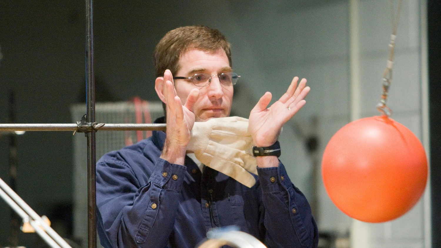 Professor David Gerdes performs a physics demonstration using a plastic ball on a string.